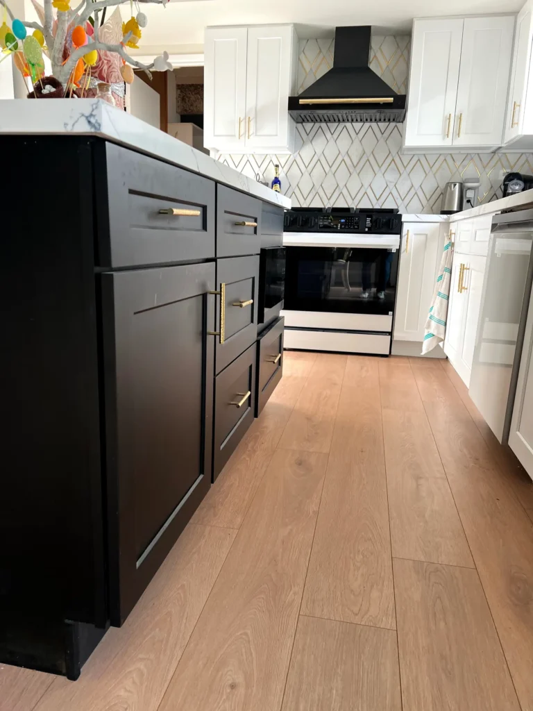 kitchen renovation featuring custom cabinetry, stone countertops, new lighting, and luxury flooring