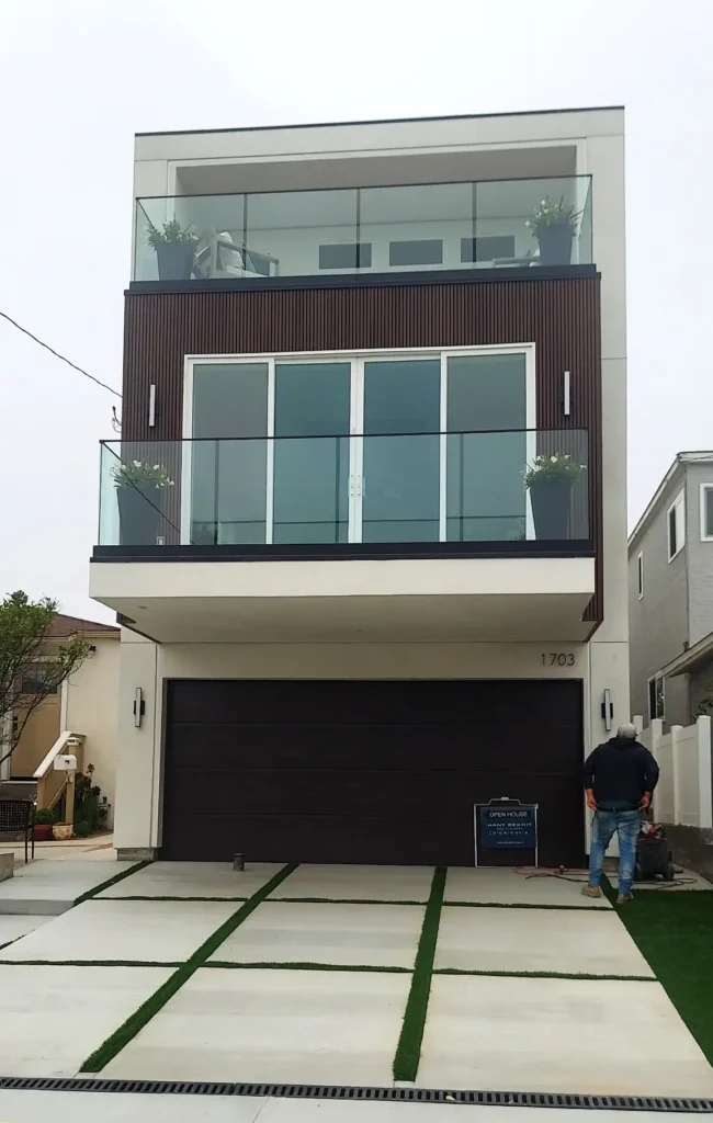 Modern three-story home facade with glass railings and wood panel accents
